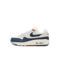 Studiozijaanzicht van de Air Max 1 Obsidian Rugged LX met contrasterende materialen, off-white basistonen en donkerblauwe Swoosh op cleane achtergrond