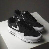 On feet van de Air Max 1 Off Noir met donkere upper, retro colorblocking en zichtbare Air-unit bij de hiel