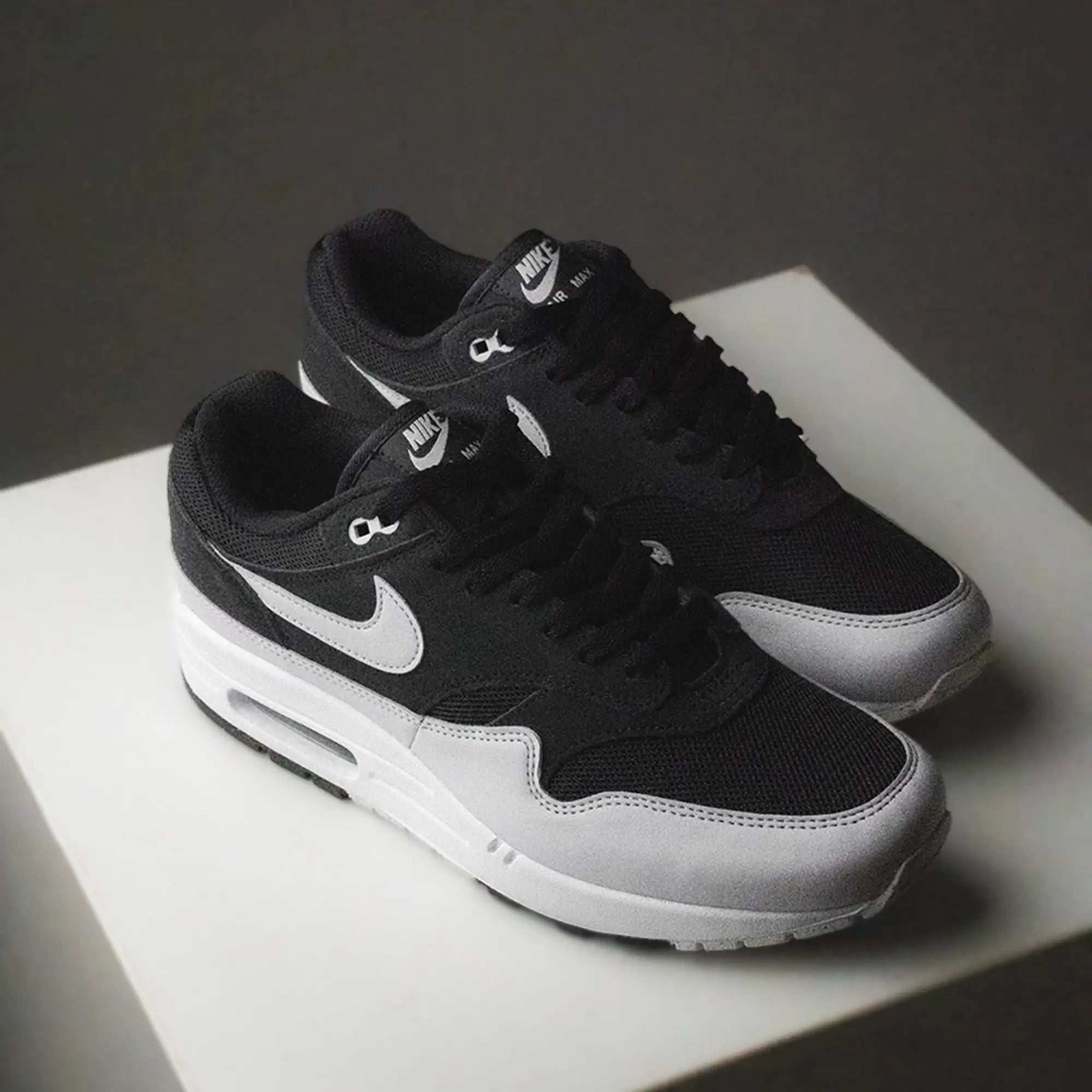 On feet van de Air Max 1 Off Noir met donkere upper, retro colorblocking en zichtbare Air-unit bij de hiel