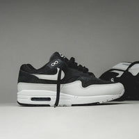 Topdown van de Air Max 1 Off Noir met grijze mesh tong, zwarte veters en strak bovenwerk in ton-sur-ton contrast