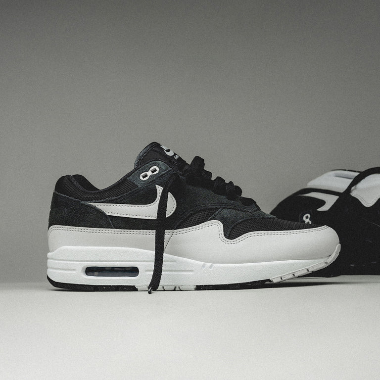 Topdown van de Air Max 1 Off Noir met grijze mesh tong, zwarte veters en strak bovenwerk in ton-sur-ton contrast