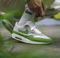 On-feet close-up met witte sportsokken en jogger, waar het frisse groen extra uitspringt tegen de urban achtergrond