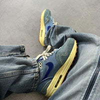 Detail van het verweerde denim en suède overlays van de Nike Air Max 1 Dirty Denim – premium materiaalgebruik via Snrkickz