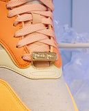 Close-up van de veterpartij met gouden lace lock en suède toebox, benadrukt door het frost-thema in de achtergrond