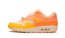Zijaanzicht van de kleurrijke Nike Air Max 1 Orange Frost, met een mix van feloranje en pastelgeel leer op een off-white zool