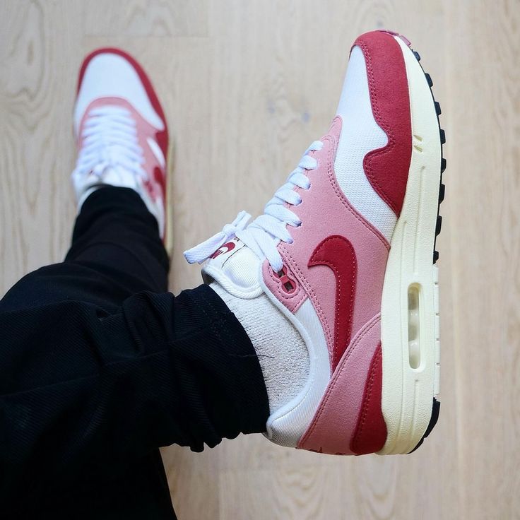 Hielshot van de Nike AM1 Red Stardust met suède hak, geborduurde Nike Air-branding en beige middenzool