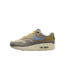 Close-up van de Safari Air Max 1 met grijze safari-panelen en blauwe Swoosh op witte achtergrond, ideaal voor mobile-first sneaker search