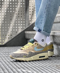 Urban sneaker shot met jeans en witte sokken, duidelijk zichtbare safari texture en lichtreflectie op het mesh toe box