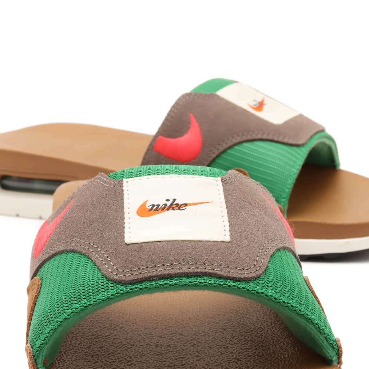 In-hand shot van Nike Air Max 1 Slide Ale Brown FJ4007-200 – luxe uitstraling, zichtbare Air Max unit en premium comfortmateriaal