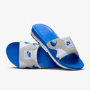 De OG Royal slides diagonaal gestapeld, met zichtbare Air Max zoolstructuur en blauwe randdetails op neutrale achtergrond