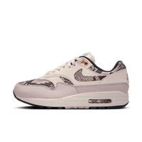 Nike Air Max 1 HF5338-100 gefotografeerd schuin van voren met zicht op de slangentextuur en gebroken witte basis die elegant contrasteert met de suède mudguard