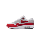 Nike Air Max 1 Low Poly in wit-rode colorway van de zijkant gefotografeerd, met cleane mudguard en transparante Air-unit voor een iconische look