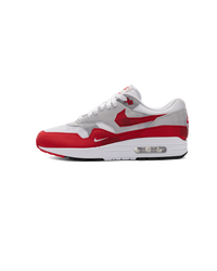 Nike Air Max 1 Low Poly in wit-rode colorway van de zijkant gefotografeerd, met cleane mudguard en transparante Air-unit voor een iconische look
