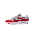 Nike Air Max 1 Low Poly in wit-rode colorway van de zijkant gefotografeerd, met cleane mudguard en transparante Air-unit voor een iconische look