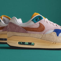 Zijaanzicht van de Nike AM1 Tan Lines WMNS met kleurrijke panelen, suède afwerking en old-school vibe