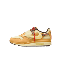 Zijaanzicht van de Travis Scott Air Max 1 in Wheat Lemon Drop colorway, met reversed Swoosh en hiking veters op een witte achtergrond