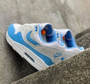 Bovenaanzicht van de Nike Air Max 1 White University Blue – zicht op tonglabel, veters en kleurverdeling via Snrkickz