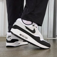 On-feet shot met zwarte trackpants, waarbij de contrasterende zool en zwarte mudguard duidelijk in beeld komen