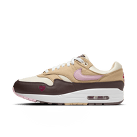 Nike Air Max 1 WMNS Valentine’s Day ‘Playful Pink’ – frontstreet shot met roze suede overlays, witte mesh basis en metallic Swoosh; trending schoen voor Gen Z gifting seizoen (HV2301‑600)