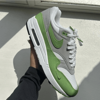 Bovenaanzicht van de Nike Air Max 1 x Patta Chlorophyll, met de zichtbare Air-unit en afgeronde toebox, waarbij de details van de sneaker in natuurlijk daglicht worden vastgelegd.