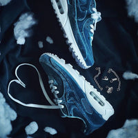 Schoen zwevend boven marineblauwe achtergrond met ketting hangend in beeld, gefocust op de details