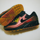 In hand shot van de Nike AM90 Metallic Copper met glimmende details, mesh bovenwerk en zachte suède rond de kraag