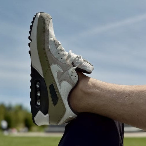 On feet van de Air Max 90 Neutral Olive met tonale earth tones, retro paneling en zichtbare Air-unit in de hak