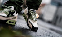 Topdown van de Nike Air Max 90 Neutral Olive met beige tong, olijfgroene veters en natuurlijke colorblock styling