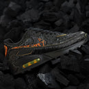 De Volcano QS HF3248-001 geplaatst op zwarte kolenachtergrond, feloranje vlamdetails contrasteren sterk met het donkere leer