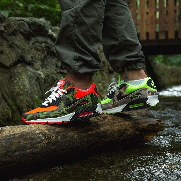 In hand shot van de Nike AM90 Reverse Duck Camo met textiele afwerking, infrared veters en army-green camo details