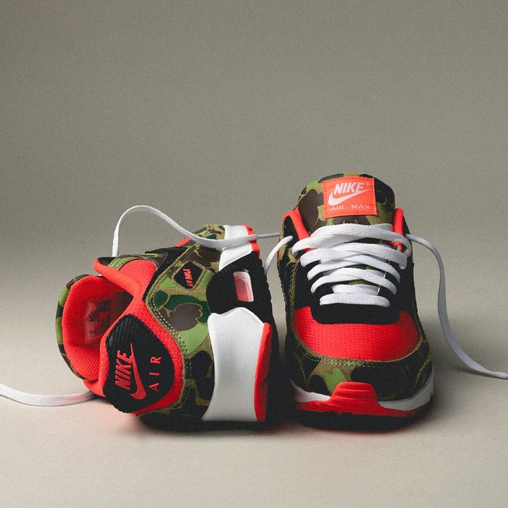 On feet van de Air Max 90 Reverse Duck Camo met opvallende rode upper, camouflagepanelen en zichtbare Air-unit