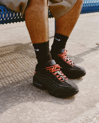 Close‑up van de Nike Air Max 95 Levi’s Black – focus op gerafeld 14‑oz. jeansmaterialen, visible Max Air units en co‑branding ‘dollar bill’ sockliner; top voor legit‑check visuals