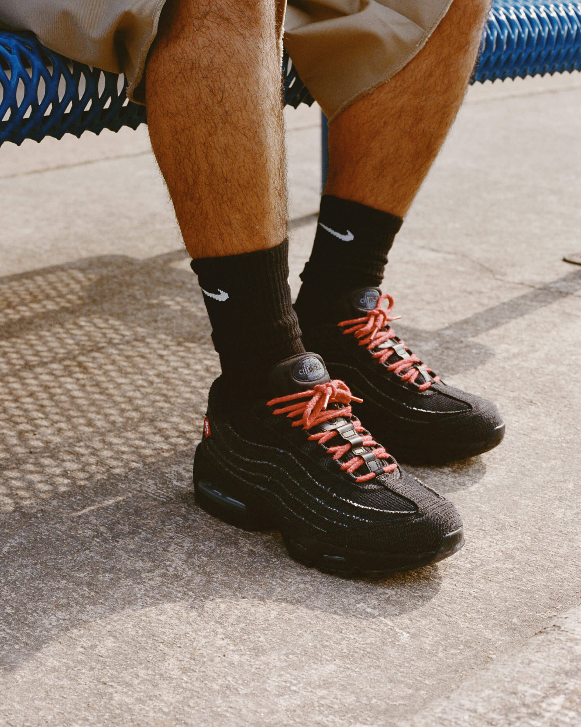 Close‑up van de Nike Air Max 95 Levi’s Black – focus op gerafeld 14‑oz. jeansmaterialen, visible Max Air units en co‑branding ‘dollar bill’ sockliner; top voor legit‑check visuals
