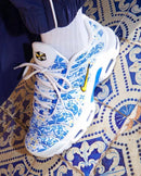 Close-up van de Nike Air Max Plus Lisboa met glanzende TPU-lijnen en diepe rode kleurverloop, premium afwerking met gouden accenten, vastgelegd in studio door Snrkickz.