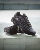 Nike Air Max Plus PSG Paris Saint-Germain Black IB2253-001 in paar gefotografeerd bij daglicht, combinatie van sportieve elegantie en clubstijl, stijlvolle limited edition vastgelegd door Snrkickz.