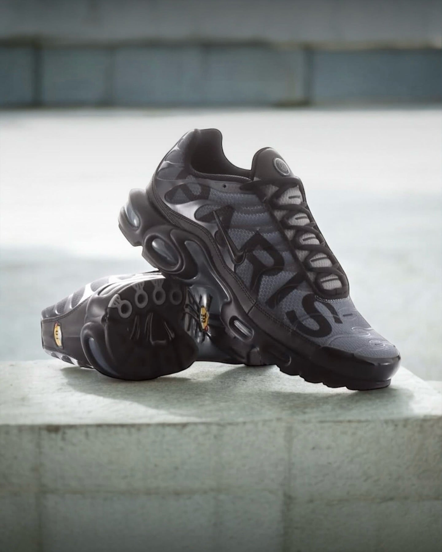 Nike Air Max Plus PSG Paris Saint-Germain Black IB2253-001 in paar gefotografeerd bij daglicht, combinatie van sportieve elegantie en clubstijl, stijlvolle limited edition vastgelegd door Snrkickz.