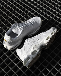 Bovenaanzicht van de Nike Air Max Plus Sail Pure Platinum Silver FN7813-001 met witte zool en metallic mesh structuur, moderne opname op zwarte achtergrond, gefotografeerd door Snrkickz.