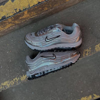 Zijaanzicht van beide sneakers op straat gefotografeerd, met zicht op Max Air zool, zilveren panelen en techwear styling