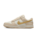 Zijaanzicht van de Nike Dunk Low WMNS Metallic Gold DX5930-001 met witte leren basis en glanzende gouden overlays