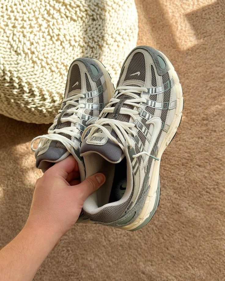 Nike P-6000 Flat Pewter FN7509-029 in paar gefotografeerd op grijze ondergrond, metallic grijstinten en subtiele contrasten creëren een tijdloze en stijlvolle uitstraling, exclusief bij Snrkickz.