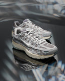 Nike P-6000 Flat Pewter FN7509-029 gedragen op straat in daglicht, combinatie van grijs en zilver zorgt voor een strakke en sportieve look, vastgelegd in urban setting door Snrkickz.