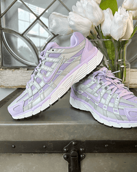 Close-up van de Nike P-6000 Lilac Bloom met glanzende overlays, mesh structuur en witte midsole, elegante pastelstijl professioneel gefotografeerd door Snrkickz.