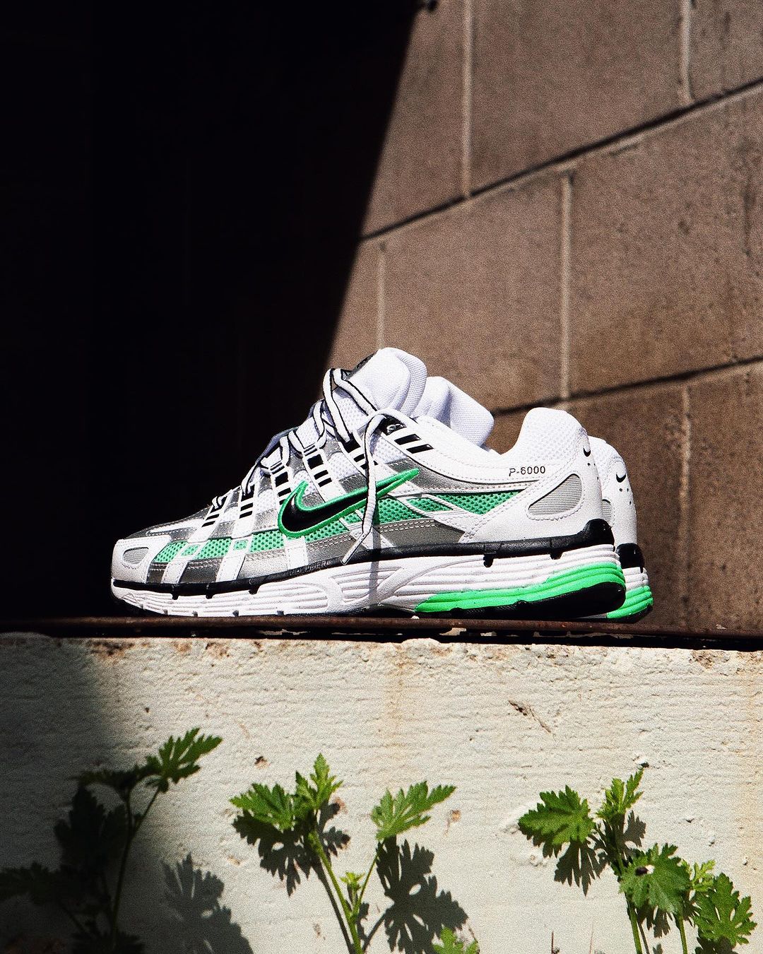 Nike P-6000 Spring Green CD6404-104 gedragen in daglicht met lichte denim, frisse combinatie van wit, groen en metallic zilver zorgt voor een energieke lente-look, vastgelegd door Snrkickz.