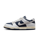 Zijaanzicht van de HUF x Nike SB Dunk Low New York met donkerblauw premium leer, witte toebox en oranje swoosh details