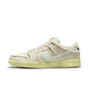 Zijaanzicht van de Nike SB Dunk Low Mummy DM0774-111 met gescheurde canvas overlays, glow-in-the-dark zool en subtiele blauwgroene accenten