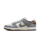 Zijaanzicht van de Yuto Horigome x Nike SB Dunk Low Grey FQ1180-001 met grijze suède upper, witte leren basis en bruine ou