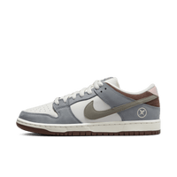 Zijaanzicht van de Yuto Horigome x Nike SB Dunk Low Grey FQ1180-001 met grijze suède upper, witte leren basis en bruine ou