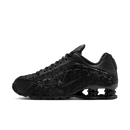 Nike Shox R4 Black Floral gefotografeerd in studio met glanzende zwarte afwerking en subtiele bloemenprint in de upper