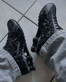 Nike Shox R4 Black Floral gedragen in casual streetwear look, gefotografeerd op grijze tegels met focus op outfitcombinatie