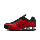 Zijaanzicht van de Nike Shox R4 in rood met zwarte details en metallic zilveren Shox-unit, tegen witte achtergrond